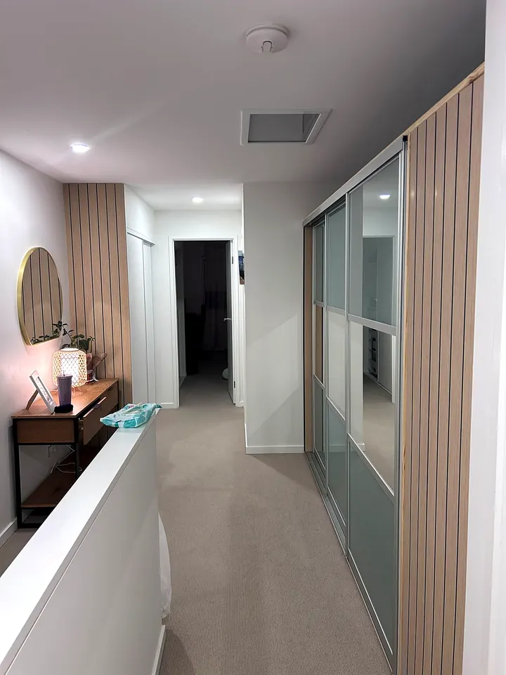 Hallway robe with sliding doors and timber battens
