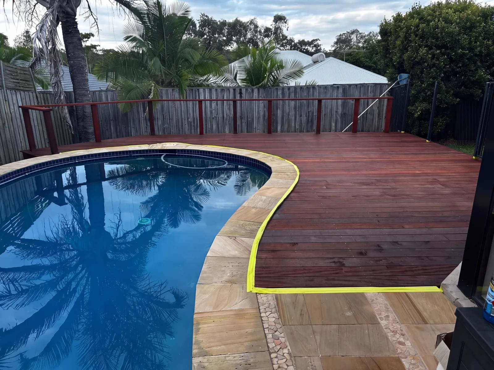 Freshly finished merbau pool deck with the coping edge still taped off